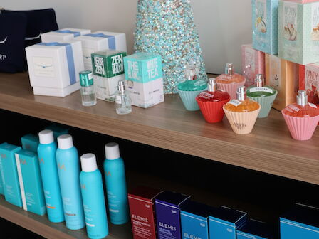 The image shows a shelf with skincare and beauty products, colorful packaging, and a decorative item resembling a tree.